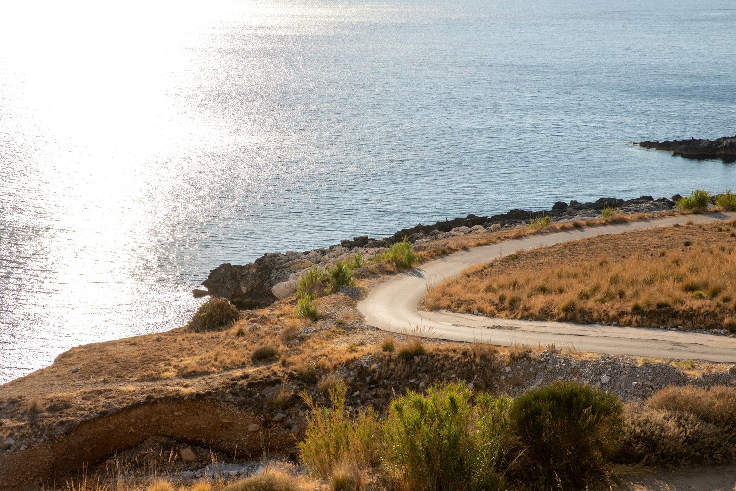 Route côtière en Sicile avec vue sur la mer.