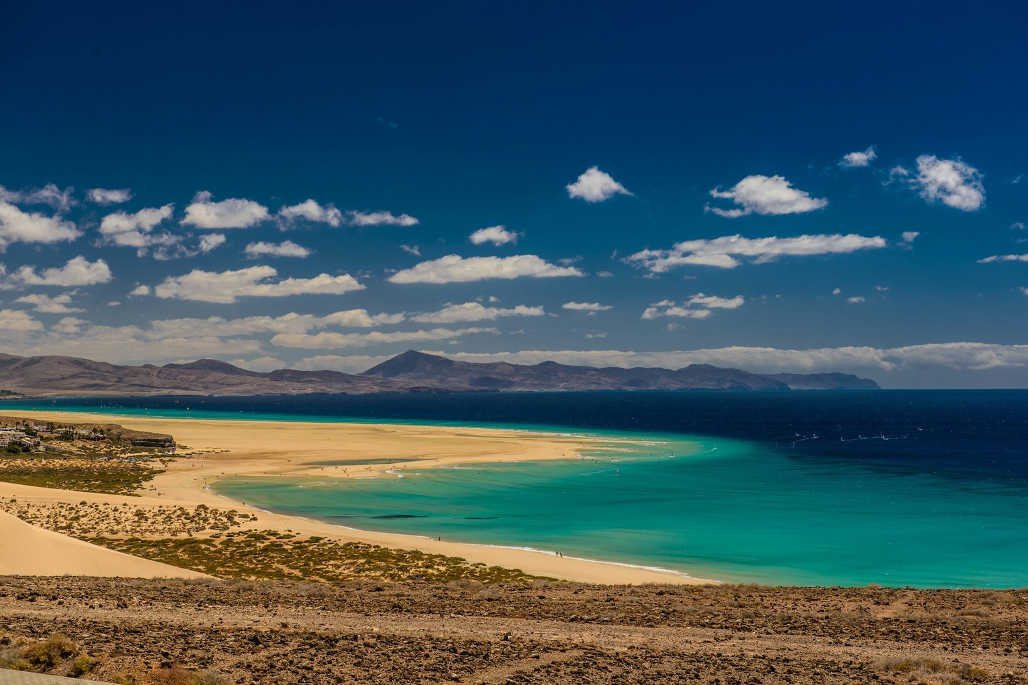 Vue panoramique de la côte nord de Fuerteventura, avec des dunes et des volcans.